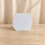 קופת צדקה שוהם מבטון לבן עם הכיתוב צדקה ומכסה נפרד